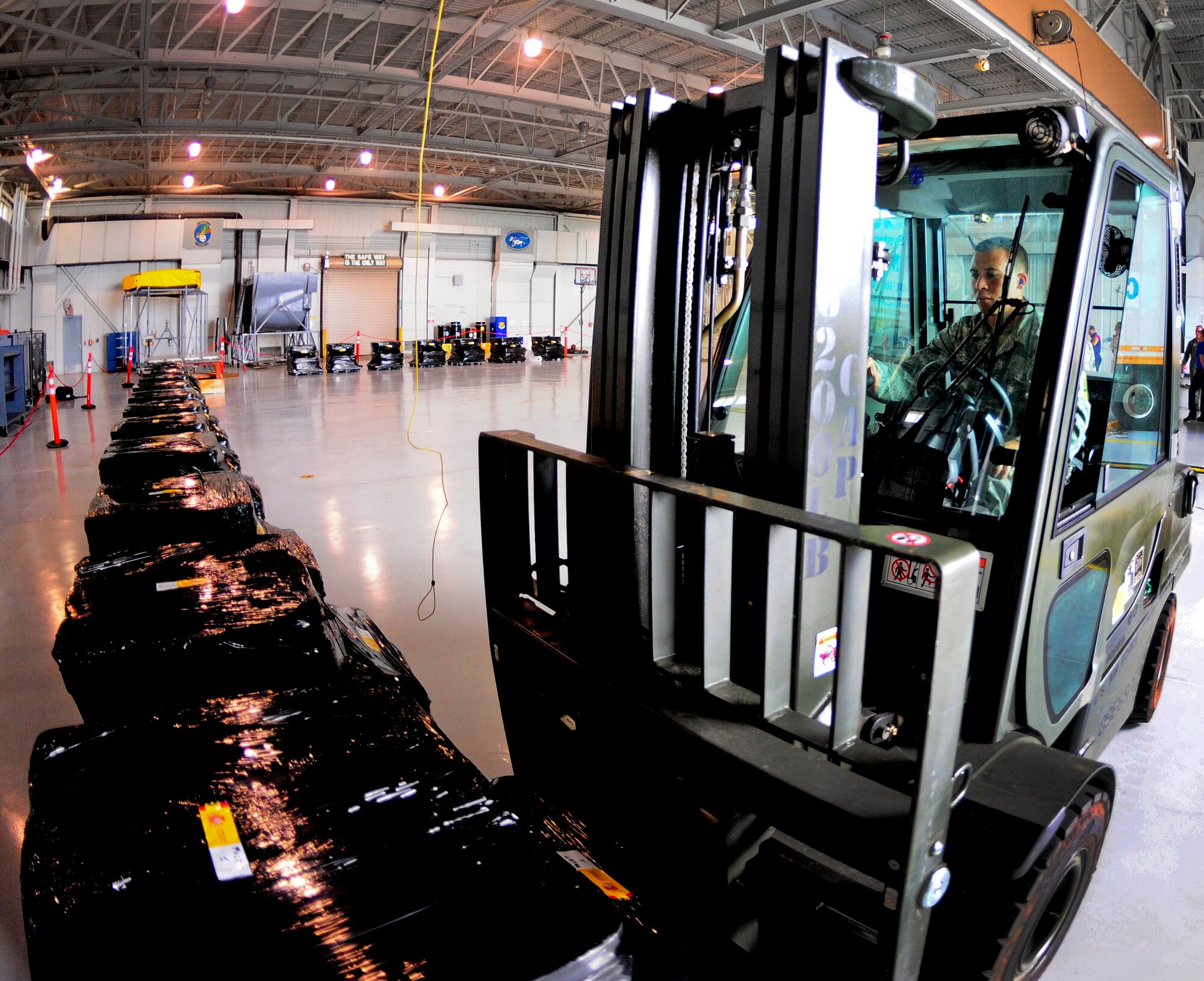 Staff Sgt. Benjamin Woods, the 6th Logistics Readiness Squadron air freight supervisor, places a pallet of Spanish coins in a line at MacDill Air Force Base, Fla., Feb. 23, 2012. The coins, which were lost at sea in the 19th century, are being palletized in preparation for their long awaited return back to Spain. (U. S. Air Force photo/Airman Basic David Tracy)