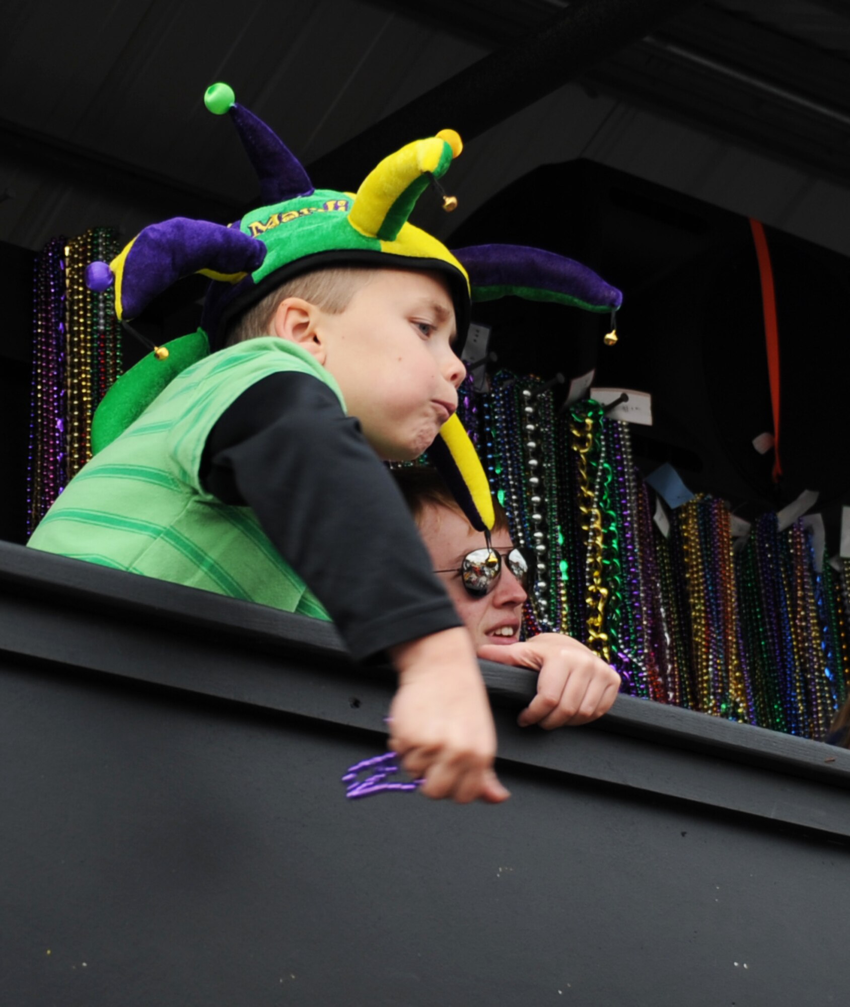 Six-year-old David Solomon, son of Devalynn and  Lt. Col. Scott Solomon, 81st Training Group deputy commander, Keesler Air Force Base, Miss., tosses a strand of beads to the crowd while riding on a float during the D’Iberville, Miss., Mardi Gras parade Feb. 19, 2012.  (U.S. Air Force photo by Kemberly Groue)