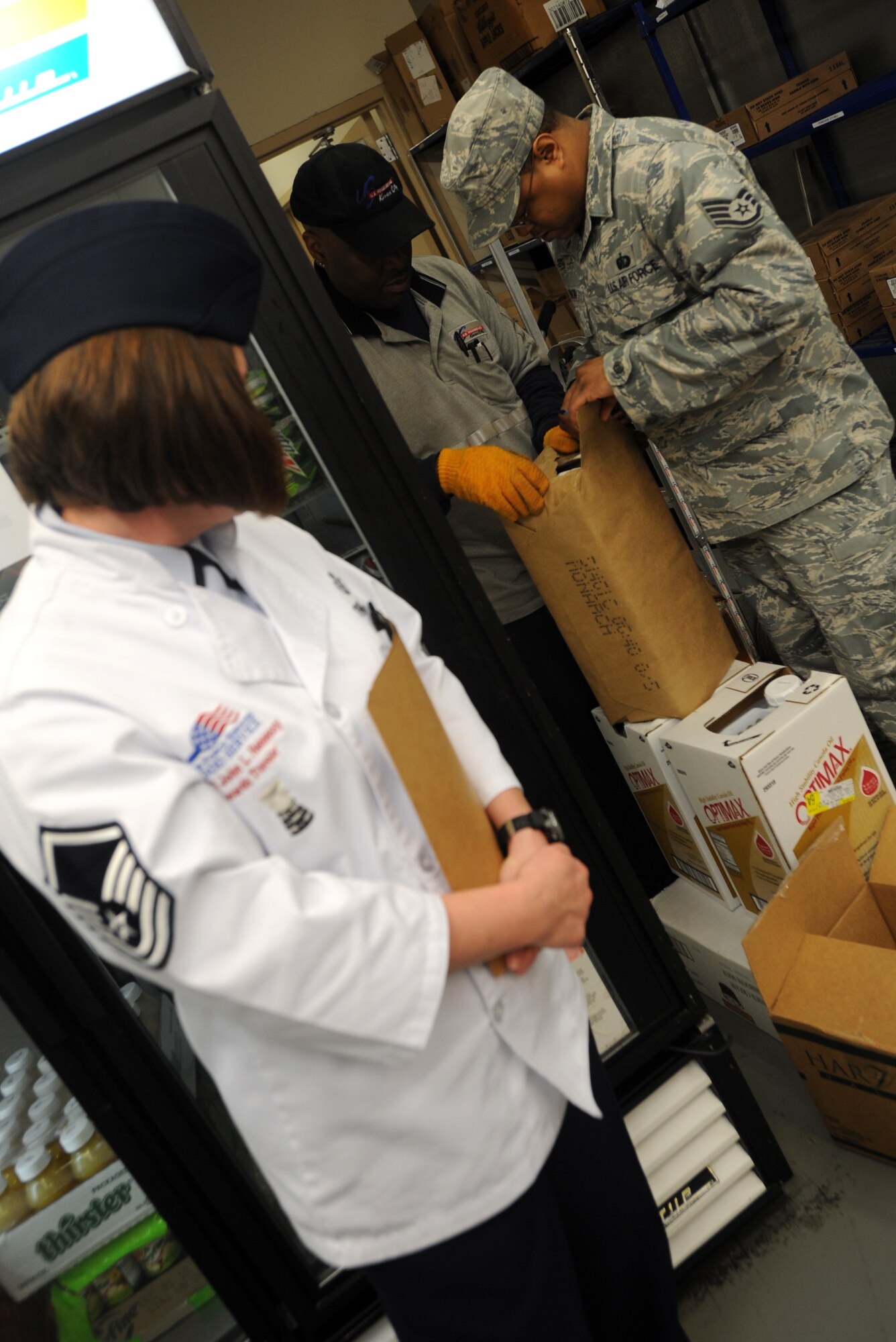 Master Sgt. Stephanie Thomas, Hennessy Evaluation Team team leader, watches as Staff Sgt. Montez Robinson, 22nd Force Support Squadron storeroom NCO in charge, inspects a bag of sugar that was delivered damaged to the Chisholm Trail Dining Facility Feb. 22, 2012, McConnell Air Force Base, Kan. Thomas inspected the delivery, as well as other aspects of the facility with her team, for the annual John L. Hennessy Trophy Award. (U.S. photo/ Airman 1st Class Laura L. Valentine)