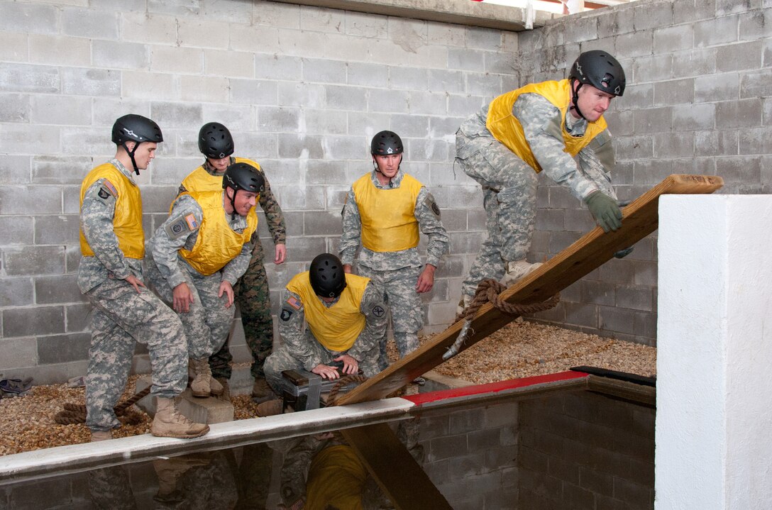 Army Capt. Rodney Yost climbs up a board, observed by his teammates, from left, Army Capt. Adam Chappel, Army Capt. Julio Fernandez, Marine Capt. Richard Jahelka, Army Capt. Shane Cohtz (kneeling) and Capt. Erik Bondhus as they tackle Project X, an obstacle course that tests teamwork and problem-solving skills Feb. 16.

Squadron Officer School hosted 33 Army captains attending the Maneuver Captains Career Course at Fort Benning, Ga. as well as two instructors, for a day. The Soldiers gained insight into the Air Force, including the professional military education offered on Maxwell, the breadth of the career fields and a better sense of how the Air Force works in general. 

The captains joined the Gryphons, a SOS squadron, in the classroom, addressing leadership models and concepts, joint experiences with Army and Air Force counterparts, communication barriers between services, career aspects and cultural differences between the services. (Air Force photo/Melanie Rodgers Cox)