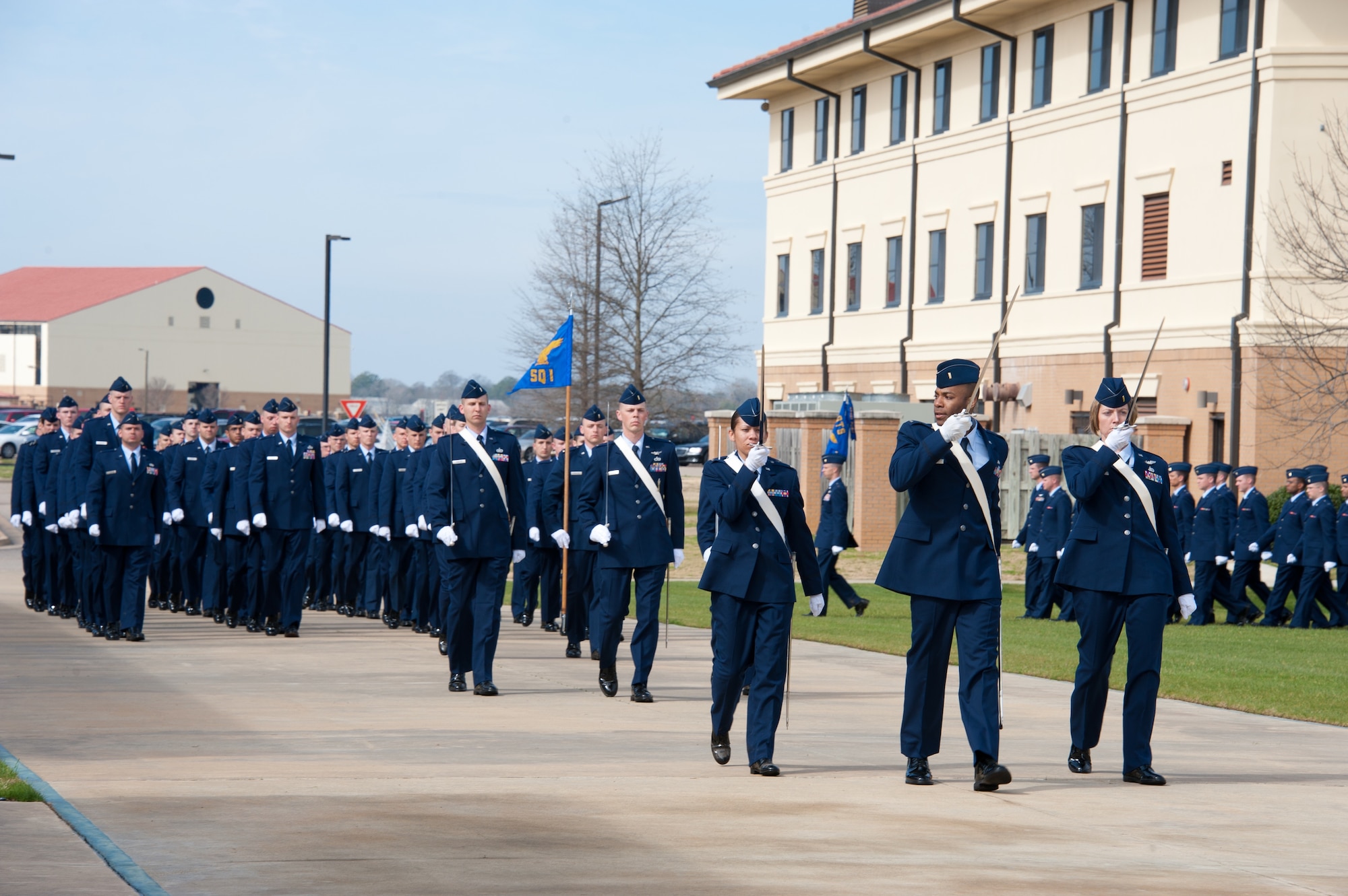 Basic Officer Training Course class 12-03 completes their graduation parade, with the two distinguished alumni reviewing the graduates Feb. 17. An A-10 flyover paid tribute to Johnson, a command A-10 pilot. (Air Force photo/Melanie Rodgers Cox)
