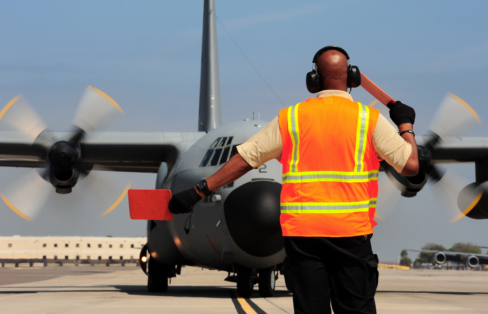 Rodney Pate, a Transit Alert employee with the 6th Aircraft Maintenance Squadron, marshalls in a Spanish C-130, Feb. 23, 2012 at MacDill Air Force Base, Fla. MacDill AFB hosted two Spanish C-130 aircraft dispatched by the Spanish Government to retrieve Spanish coins that were lost at sea in the 19th century. (U.S. Air Force photo by Airman Basic David Tracy)