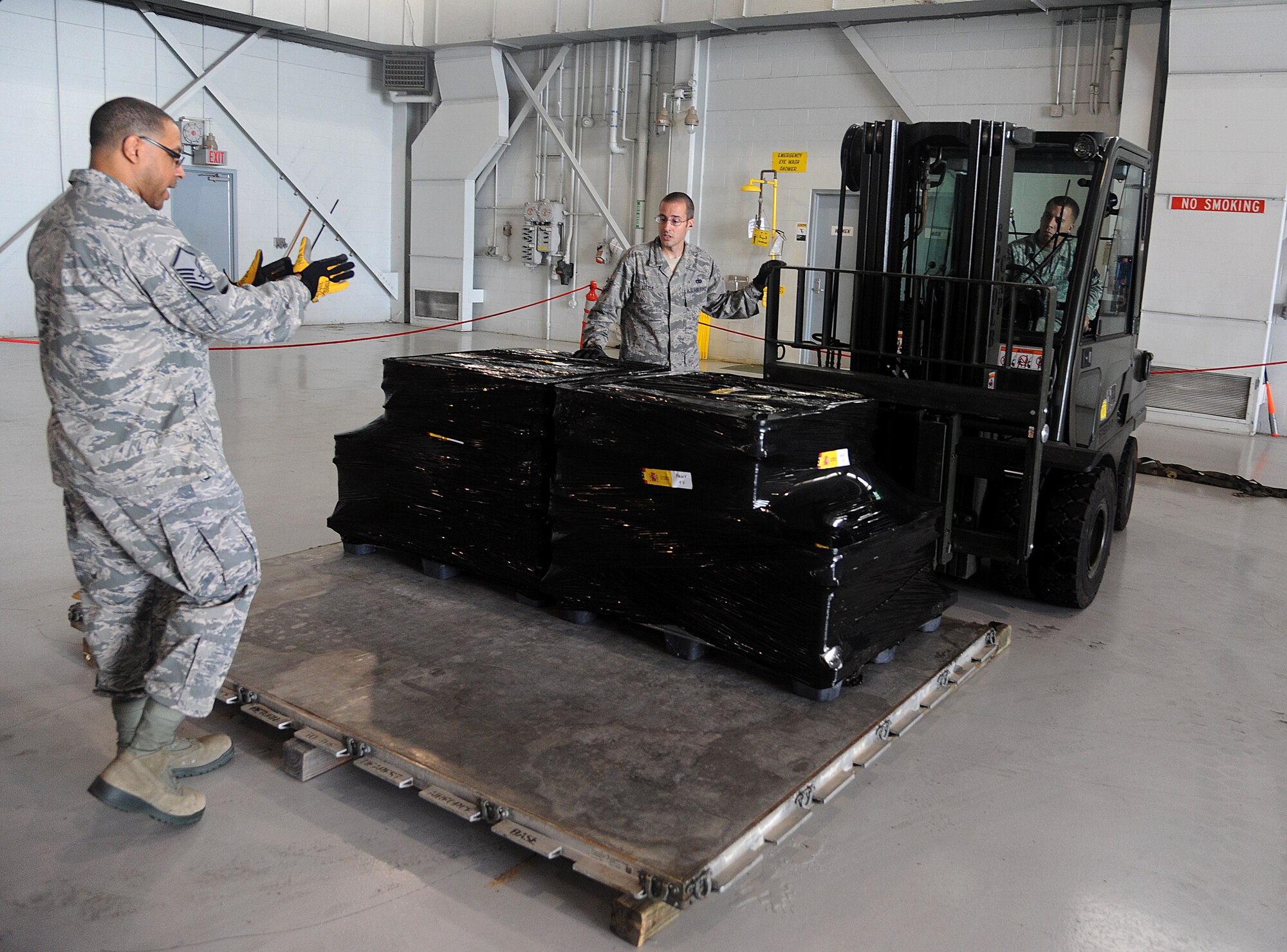 (From left to right) Master Sgt. Chris Eggleston, section chief small air terminal, Tech. Sgt. Peter Little, noncommissioned officer in charge of air freight, and Staff Sgt. Benjamin Woods, air freight supervisor, of the 6th Logistics Readiness Squadron, prepare to load Spanish coins onto an aircraft at MacDill Air Force Base, Fla., Feb. 23, 2012. The coins, which were lost at sea in the 19th century, are being palletized in preparation for their long awaited return back to Spain. (U. S. Air Force photo by Airman Basic David Tracy)