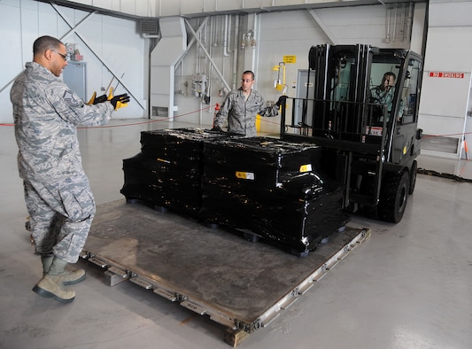 (From left to right) Master Sgt. Chris Eggleston, section chief small air terminal, Tech. Sgt. Peter Little, noncommissioned officer in charge of air freight, and Staff Sgt. Benjamin Woods, air freight supervisor, of the 6th Logistics Readiness Squadron, prepare to load Spanish coins onto an aircraft at MacDill Air Force Base, Fla., Feb. 23, 2012. The coins, which were lost at sea in the 19th century, are being palletized in preparation for their long awaited return to Spain. (U. S. Air Force photo/Airman Basic David Tracy)