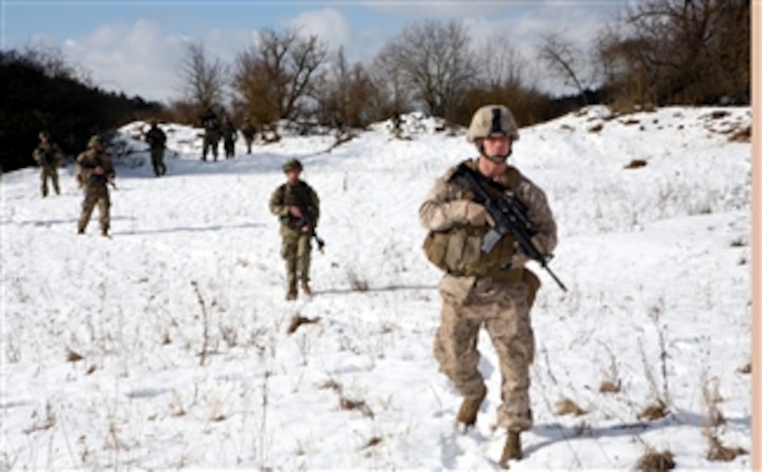 U.S. Marine Capt. Matt Wartenbe of the Georgia Liaison Team participates in a patrol with Charlie Company around the local village a few hours after the unit conducted a cordon and search operation during part of its mission rehearsal exercise at Joint Multinational Readiness Center Hohenfels, Germany, on Feb. 20, 2012.  Wartenbe is assisting the unit in preparing to support counterinsurgency operations in Afghanistan as part of Georgia Deployment Program - International Security Assistance Force.  