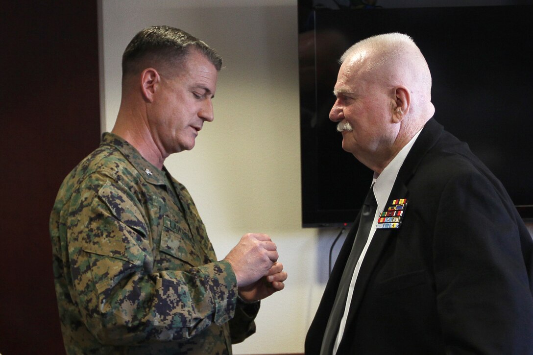Col. Michael L. Lawrence, commanding officer Marine Corps Air Station Camp Pendleton, pins the Navy and Marine Corps Medal on Charles P. Barrett, Jr., whose prompt action and courage on May 13, 1951, is recognized 60 years later at the MCAS Camp Pendleton, Feb. 24.