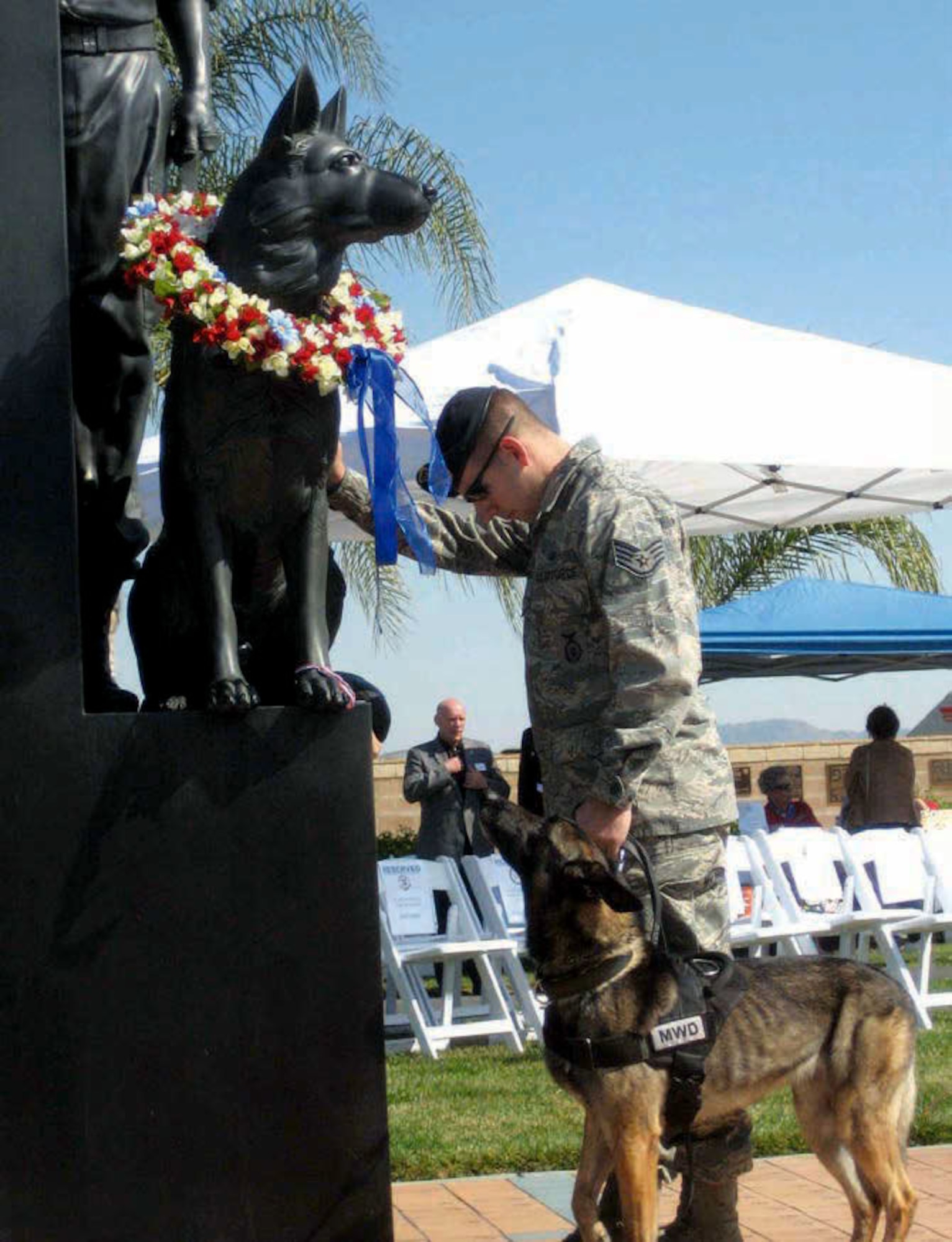 An Air Force security forces staff sergeant and his military working dog pause at the March Field Air Museum’s War Dog Memorial on Feb. 18 during the museum’s 12th Annual War Dog Remembrance Day. Military members and their working dogs participated in the event which included an obstacle course competition Sunday.  (Courtesy photo from the March Field Air Museum)

