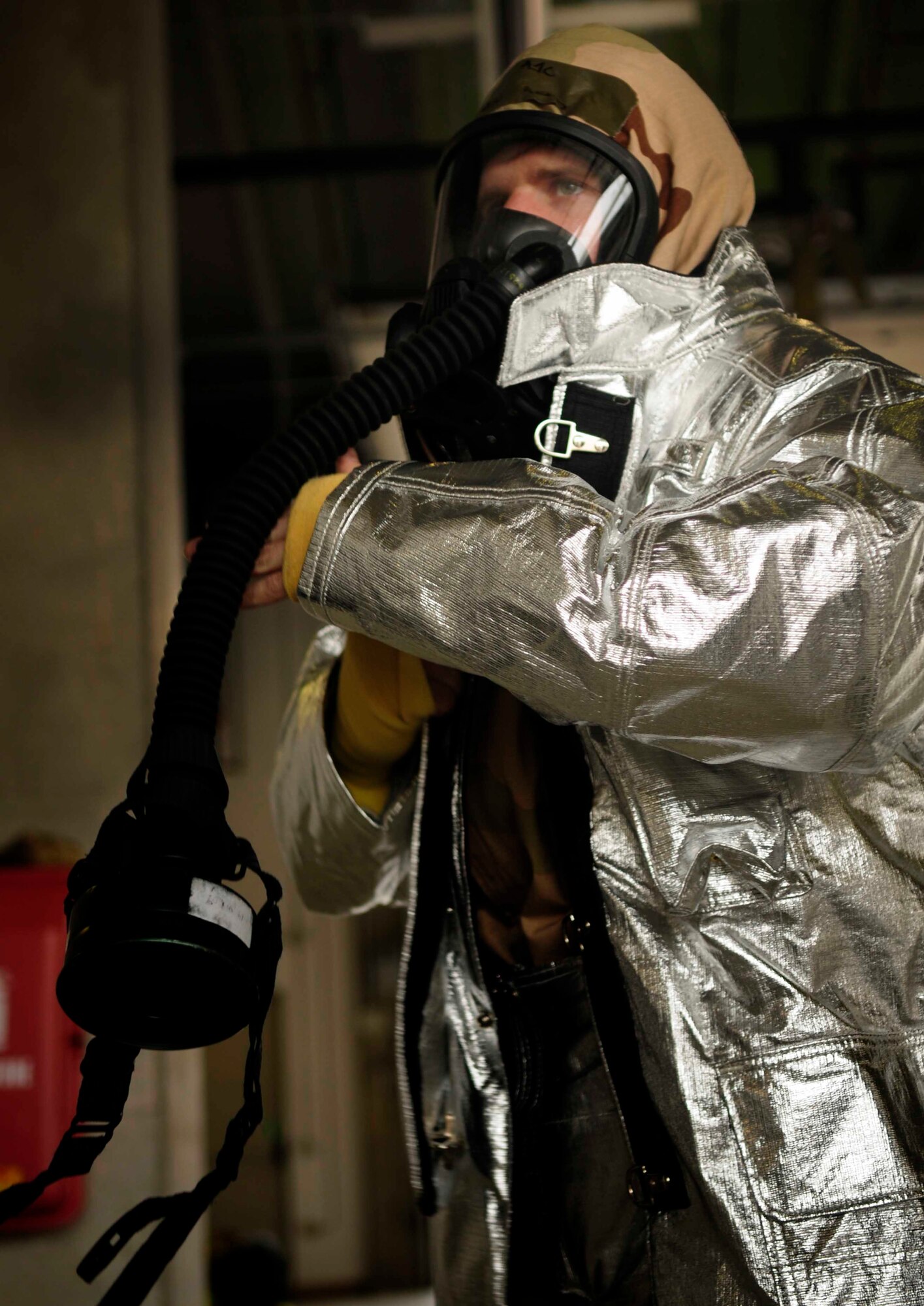 Airman 1st Class Benjamin Reed, 31st Civil Engineer Squadron firefighter, dons his mission oriented protective posture gear Feb.23 at Aviano Air Base, Italy.The bimonthly training provides great positioning and full fire suppression coverage of the entire building. (U.S. Air Force photo/Airman 1st Class Briana Jones)