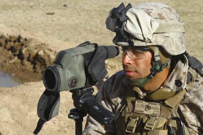 Gunnery Sgt. Rafael Iturrino, the Embedded Training Team staff noncommissioned officer-in-charge with 2nd Battalion, 4th Marine Regiment, looks at distant rifle targets during advanced marksmanship training for Afghan National Army soldiers here, Feb. 25. The top shooters from 3rd Kandak, 2nd Brigade, 215th Corps, were selected to learn precision shooting from scout snipers with 2nd Battalion, 4th Marine Regiment. The Marines chose the best students to serve as marksmanship instructors and pass on their new skills to other Afghan soldiers.