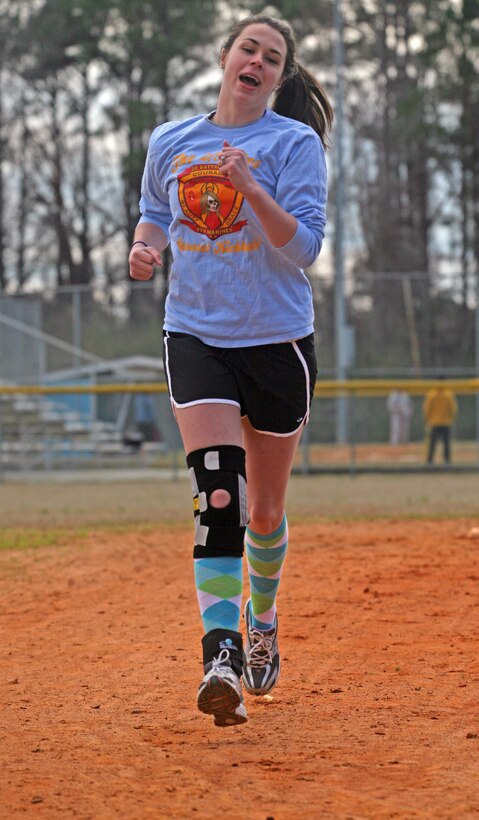 Representing 2nd Battalion, 9th Marine Regiment, 2nd Marine Division, Cassie Weeks, a player for the 2/9ettes, kicks makes a dash for third plate during the Spouses Lejeune Area Kickball Association opening day tournament aboard Marine Corps Base Camp Lejeune, N.C., Feb. 26. The league started with only two teams and has since grown into 24.