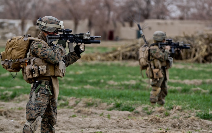 Corporal Ian Ward, a squad leader with 3rd Platoon, Lima Company, looks through the scope of his rifle to identify some suspicious people, with Cpl. Manuel Ortiz, a team leader with the platoon, during a patrol Feb. 27, 2012. ::r::::n::Ward, currently deployed with 3rd Battalion, 7th Marine Regiment, mentored his Marines, training them for when he leaves the squad. Ward put junior Marines in leadership billets, giving them valuable experience.::r::::n::