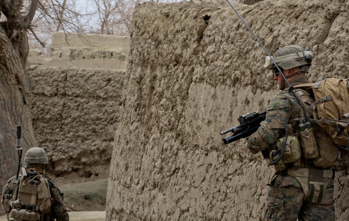 Corporal Ian Ward, a squad leader with 3rd Platoon, Lima Company, watches his team leader, Cpl. Manuel Ortiz, also with 3rd Battalion, 7th Marine Regiment, during a patrol Feb. 26, 2012. The Marines went from compound to compound, asking the local people about insurgent activity. After talking to numerous households, the Marines returned to debrief and talk about what they learned.