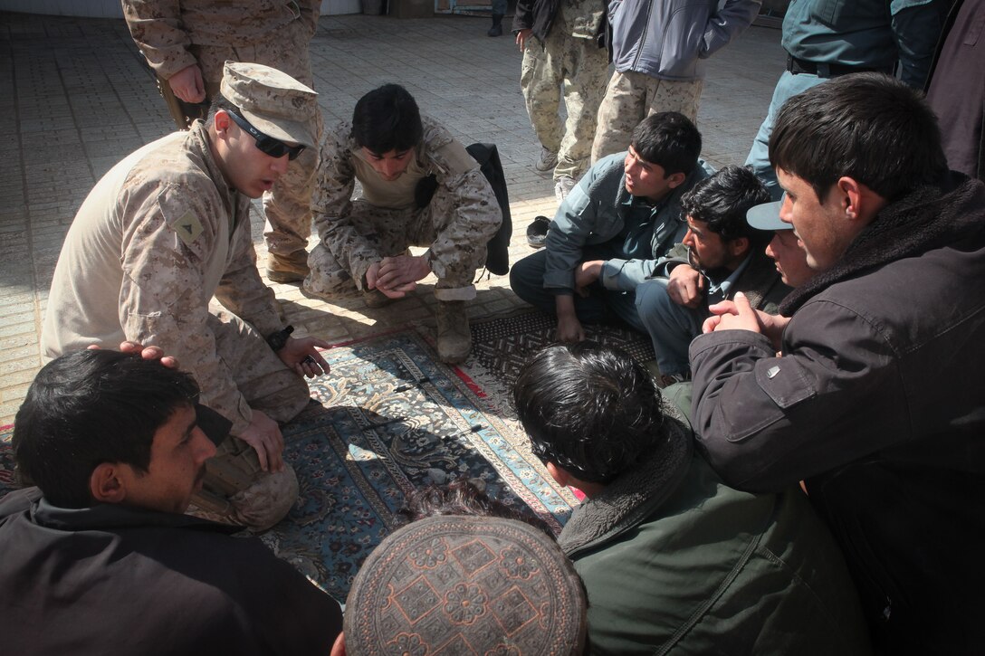 Lance Cpl. Matthew Spencer, a police advisor with Regimental Combat Team 5 Police Advisory Team, instructs Afghan Uniformed Police officers in proper techniques and procedures to use at vehicle check points. The advisory team spent four days conducting refresher courses to help the Afghan police in their role providing security for Marjah. (U.S. Marine Corps photo by Lance Cpl. Tyler Reiriz)