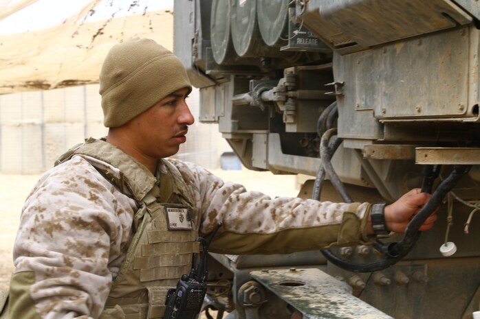 Sergeant Ricardo A. Monge, a section chief with 3rd Platoon, Tango Battery, 5th Bn., 11th Marine Regiment, arms the training module of the High Mobility Artillery Rocket System during a dry-fire drill here, Feb. 26. Monge, a 24-year-old native of Los Angeles, leads a three-man launcher team in daily drills to increase their response time to support requests. The HIMARS allows the Marines to support fire missions within minutes and deliver precision fire within one meter of the target location.