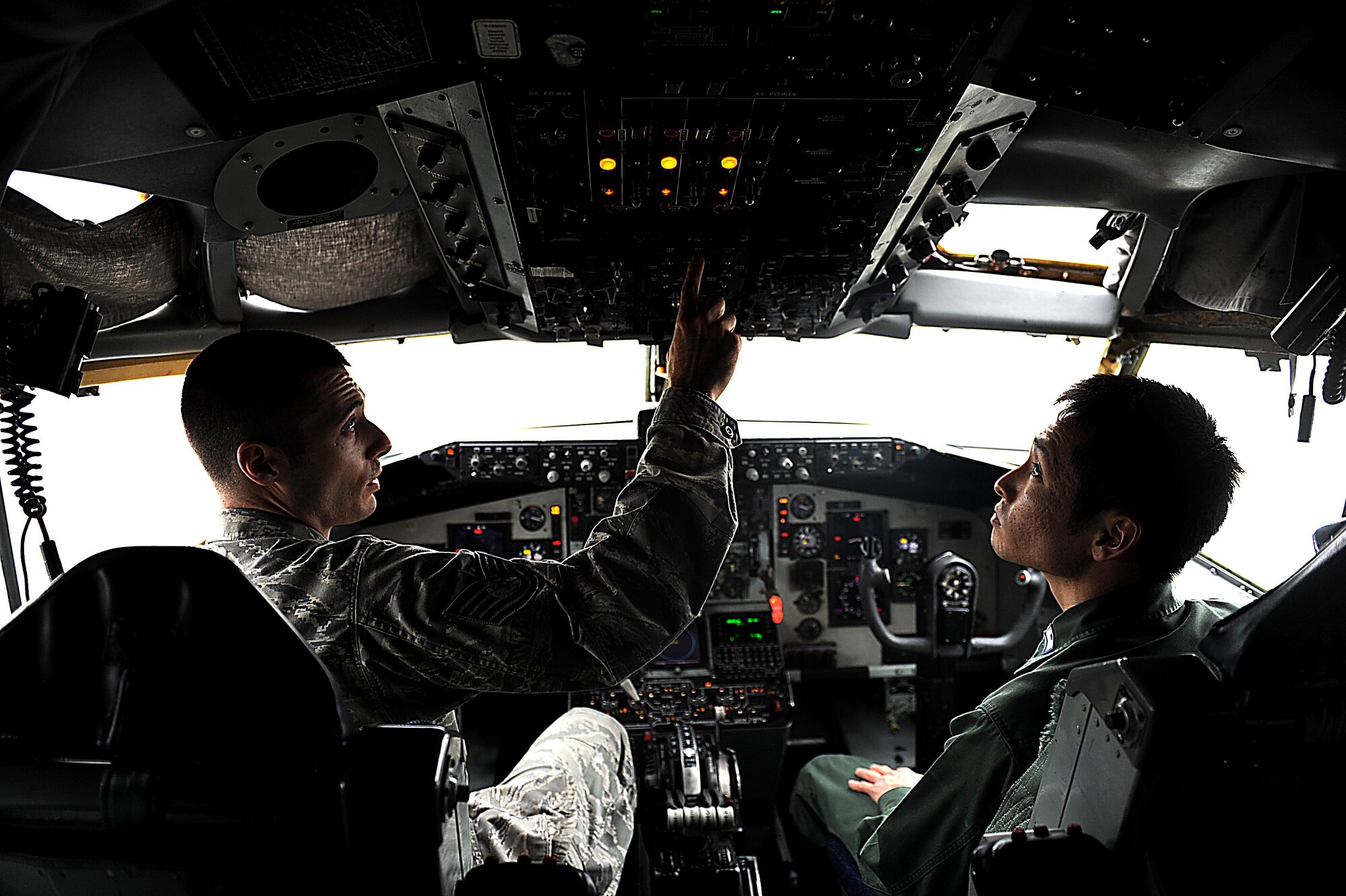 U.S. Air Force Tech. Sgt. Matthew Crawford, 718th Aircraft Maintenance Squadron instrument and flight control systems craftsman, discusses the steps of performing an operational check on the auto pilot function on a U.S. Air Force KC-135 Stratotanker refueling aircraft on Kadena Air Base, Feb. 24, 2012. For the past week, Crawford has been working with Japan Air Self-Defense Force Staff Sgt. Shuzo Masuda during the NCO exchange program. (U.S. Air Force photo by Airman 1st Class Brooke P. Beers/Released)