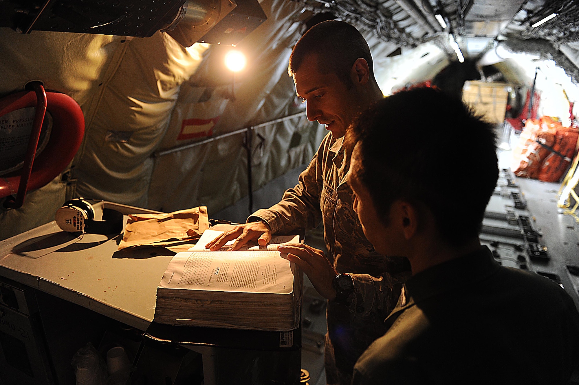 U.S. Air Force Tech. Sgt. Matthew Crawford, 718th Aircraft Maintenance Squadron instrument and flight control systems craftsman, goes over technical orders with Japan Air Self-Defense Force Staff Sgt. Shuzo Masuda on Kadena Air Base, Feb. 24, 2012. Masuda was taking part in the week long NCO exchange program. (U.S. Air Force photo by Airman 1st Class Brooke P. Beers/Released)