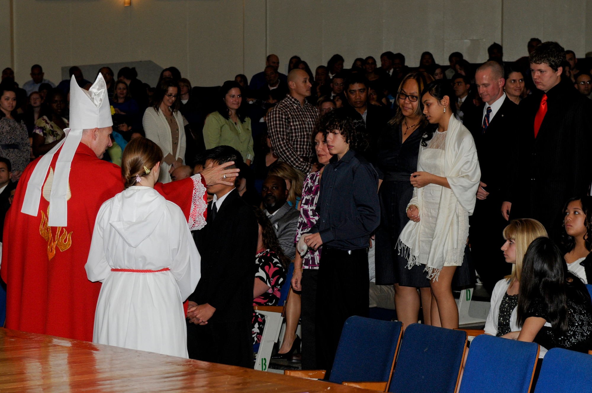 U.S. Army Chaplain (Col.) Frank Richard Spencer, auxiliary bishop of the archdiocese for military services, confirms a group of 84 Catholic candidates during a multi-service confirmation for military bases around Okinawa at the Kadena High School on Kadena Air Base, Japan, Feb. 21, 2012. Each year, a bishop comes to Okinawa to be present for the confirmation of Catholic candidates on the island. (U.S. Air Force photo by Airman 1st Class Tara A. Williamson/Released)