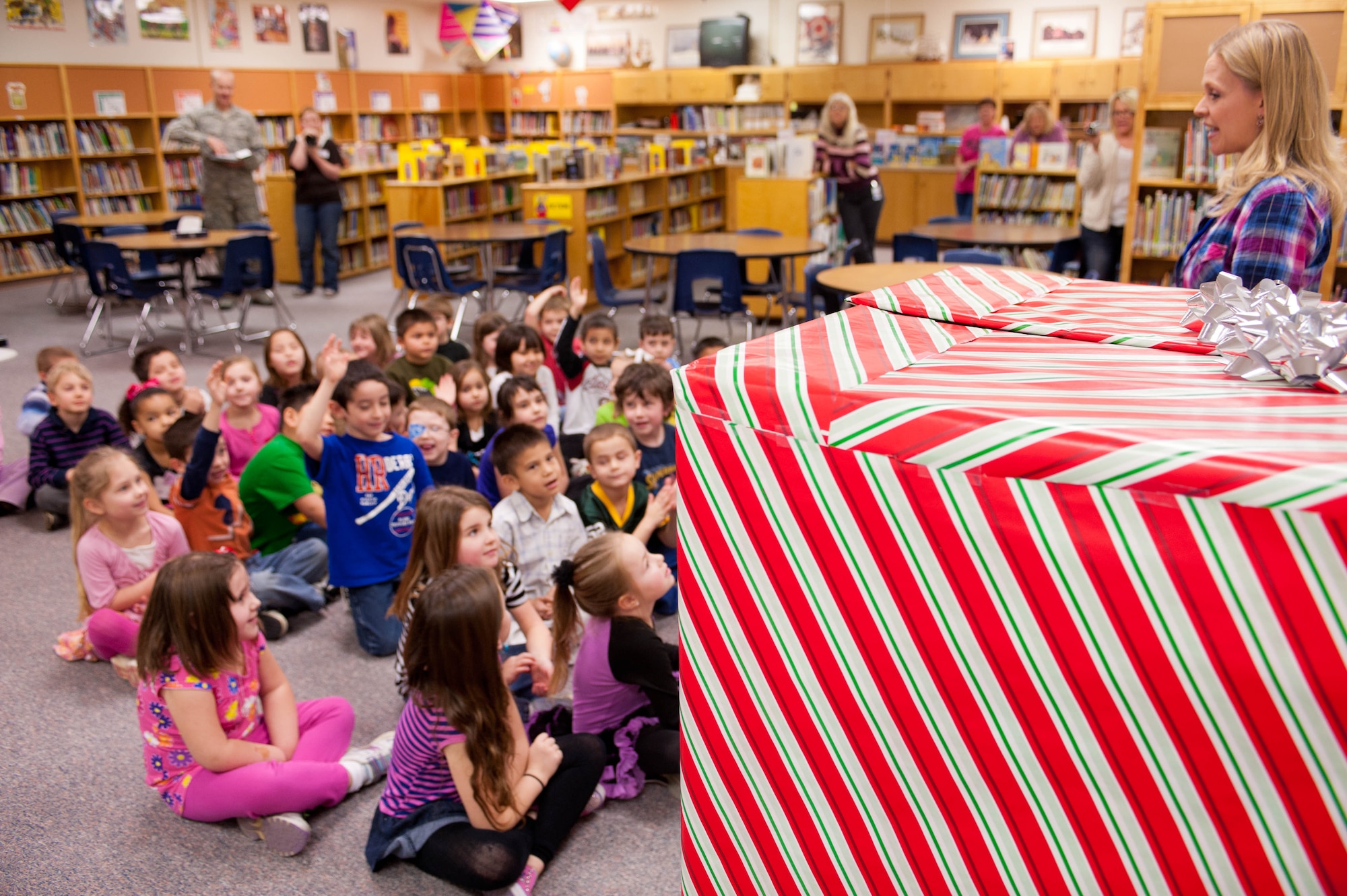 Tia Sparby, kindergarten teacher, brings kindergarten students to the library for a big surprise at the Robbinsdale Elementary School in Rapid City, S.D., Feb. 17, 2012. The surprise was Staff Sgt. George Munoz, 28th Munitions Squadron weapon systems craftsman, jumping out of a box to surprise his son. Until that morning, it had been a year since Munoz had seen his son, due to his year-long assignment to Kunsan Air Base, South Korea. (U.S. Air Force photo by Airman 1st Class Zachary Hada/Released)
