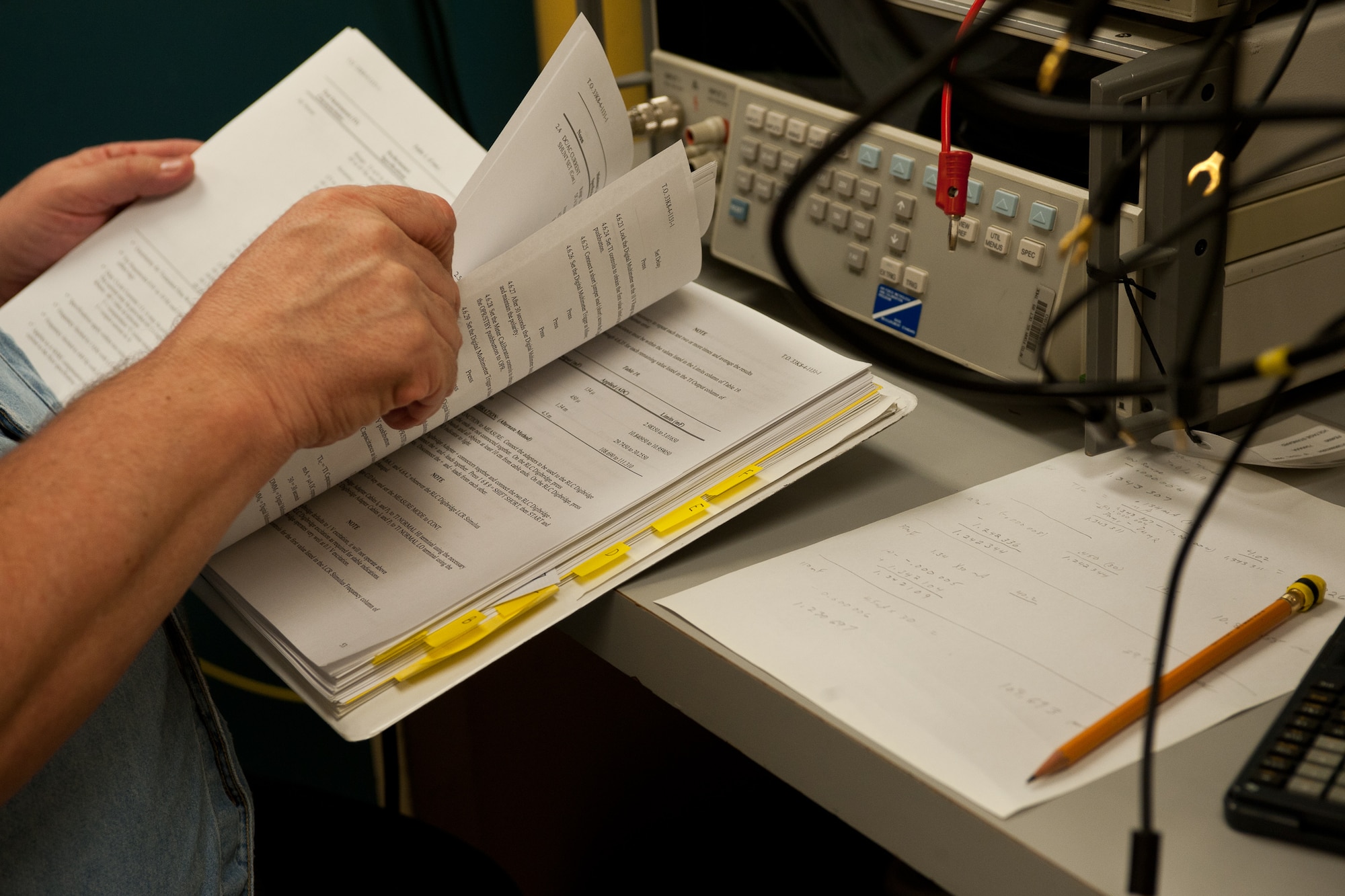 Charles Eickhoff, 28th Maintenance Squadron calibration technician, looks through a technical order while performing precision measurements on Ellsworth Air Force Base, S.D., Feb. 16, 2012. Technical orders list exact specifications that allow the precision measurement equipment laboratory to calibrate instruments such as the altitude, air pressure, and oil pressure gages for accuracy. (U.S. Air Force photo by Airman Alystria Maurer/Released)