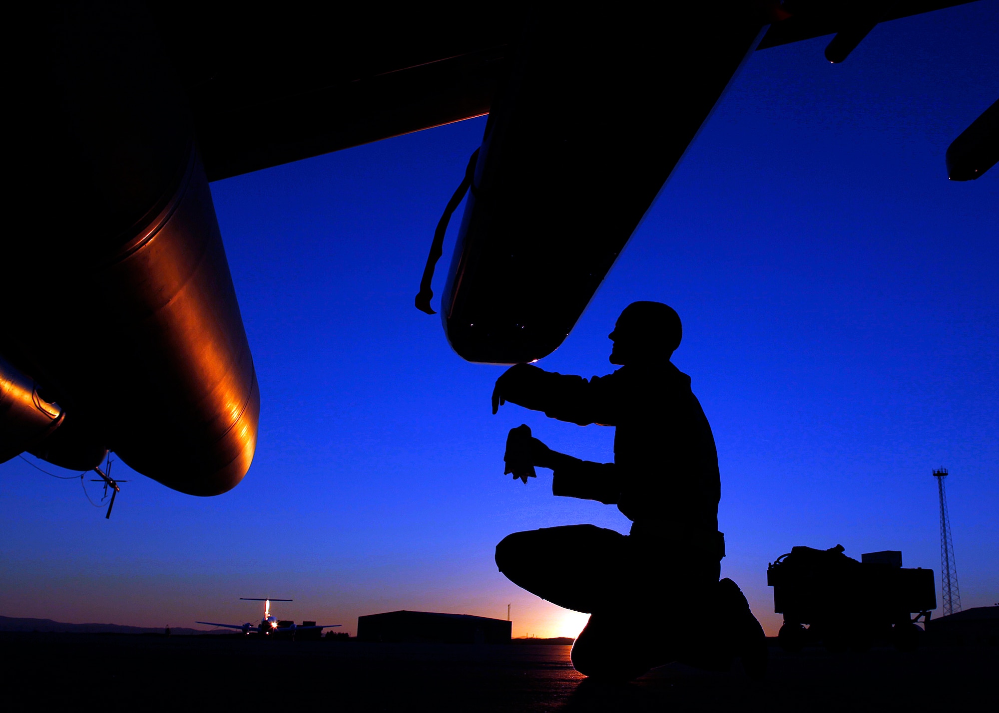 As the sun fades over the Edwards flightline, a crew chief with the 445th
Aircraft Maintenance Unit performs a post-flight inspection on an F-16
during the swing shift. The 445th AMU is just one of many units that provide
maintenance support to Edwards Air Force Base aircraft during the day, night
and weekend. (U.S. Air Force photo by Jet Fabara)
