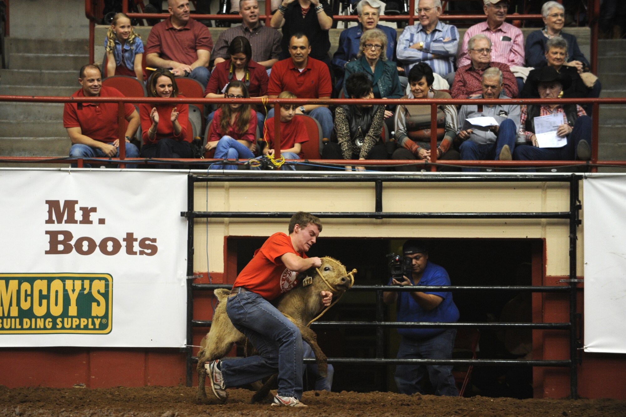 SAN ANGELO, Texas -- Col.  Mark Damiano, 17th Training Wing Commander, and his family (front row left) watch the calf scramble during military appreciation night at the 80th Annual San Angelo Stock Show and Rodeo Feb. 22. This year’s rodeo included 1257 rodeo contestants, more than 10,000 livestock entries, moer than  $500k combined rodeo purse, and more than $650k in scholarships and premium sale funds awarded to Texas youth. (U.S. Air Force photo/Staff Sgt. Laura R. McFarlane)