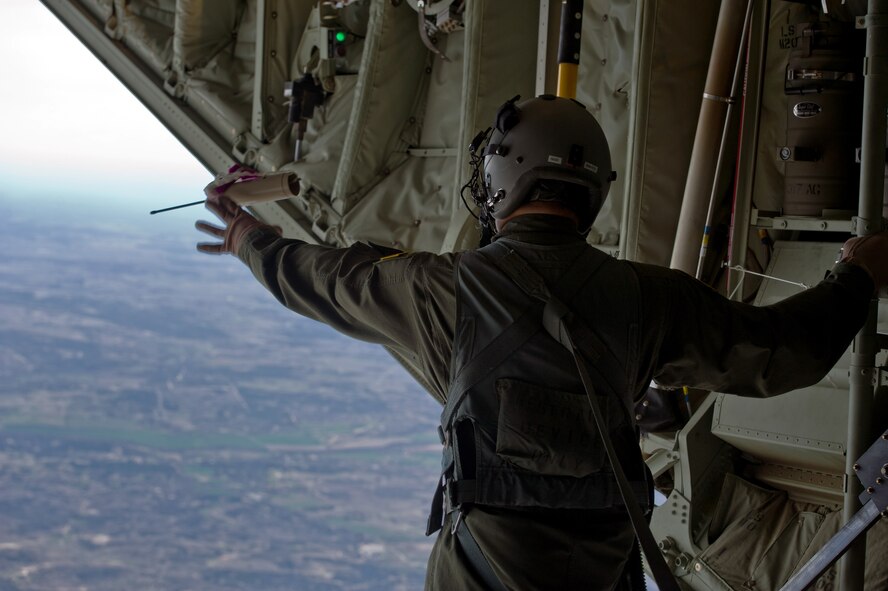 U.S. Air Force Master Sgt. Malcolm Mercado, 317th Airlift Group loadmaster, throws a dropsonde out of a 317th Airlift Group C-130J during training Feb. 22, 2012, at Fort Hood, Texas. A dropsonde is a weather reconnaissance device created by the National Center for Atmospheric Research, designed to be dropped from an aircraft at altitude to more accurately measure weather conditions as the device falls to the surface. (U.S. Air Force photo by Staff Sgt. Jonathan Snyder/Released)