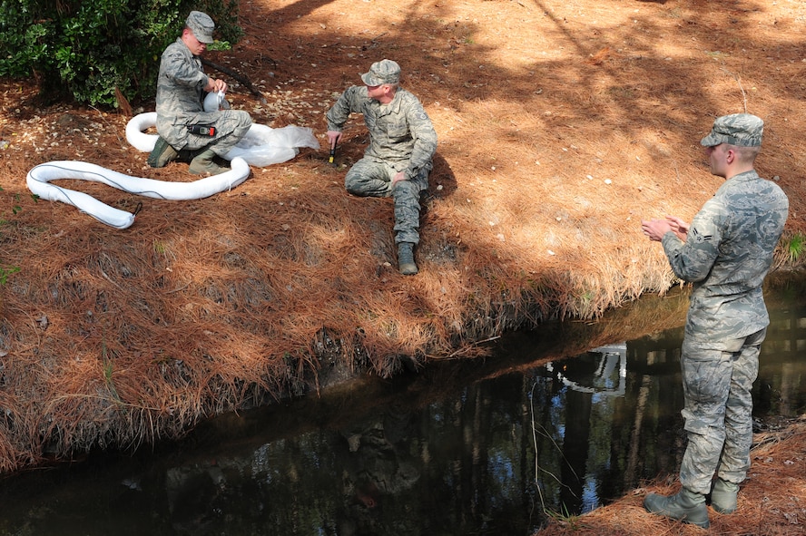U.S. Air Force Senior Airman Shane O'Neill connects absorbent booms as Staff Sgt. Jay Wright and Airman 1st Class Randall Gilley Jr. wait to place them in the water during a fuel spill exercise on Seymour Johnson Air Force Base, N.C., Feb. 23, 2012. The booms allow water to continue to pass through but can absorb up to 10 times its weight in fuel.  O’Neill, from Goldsboro, N.C., and Wright, Kingsport, Tenn., are 4th Civil Engineer Squadron water and fuels systems maintenance apprentices. Gilley Jr., from Dripping Springs, Texas, is a 4th CES water and fuels systems maintenance journeyman.  (U.S. Air Force photo/Airman 1st Class Mariah Tolbert/Released)