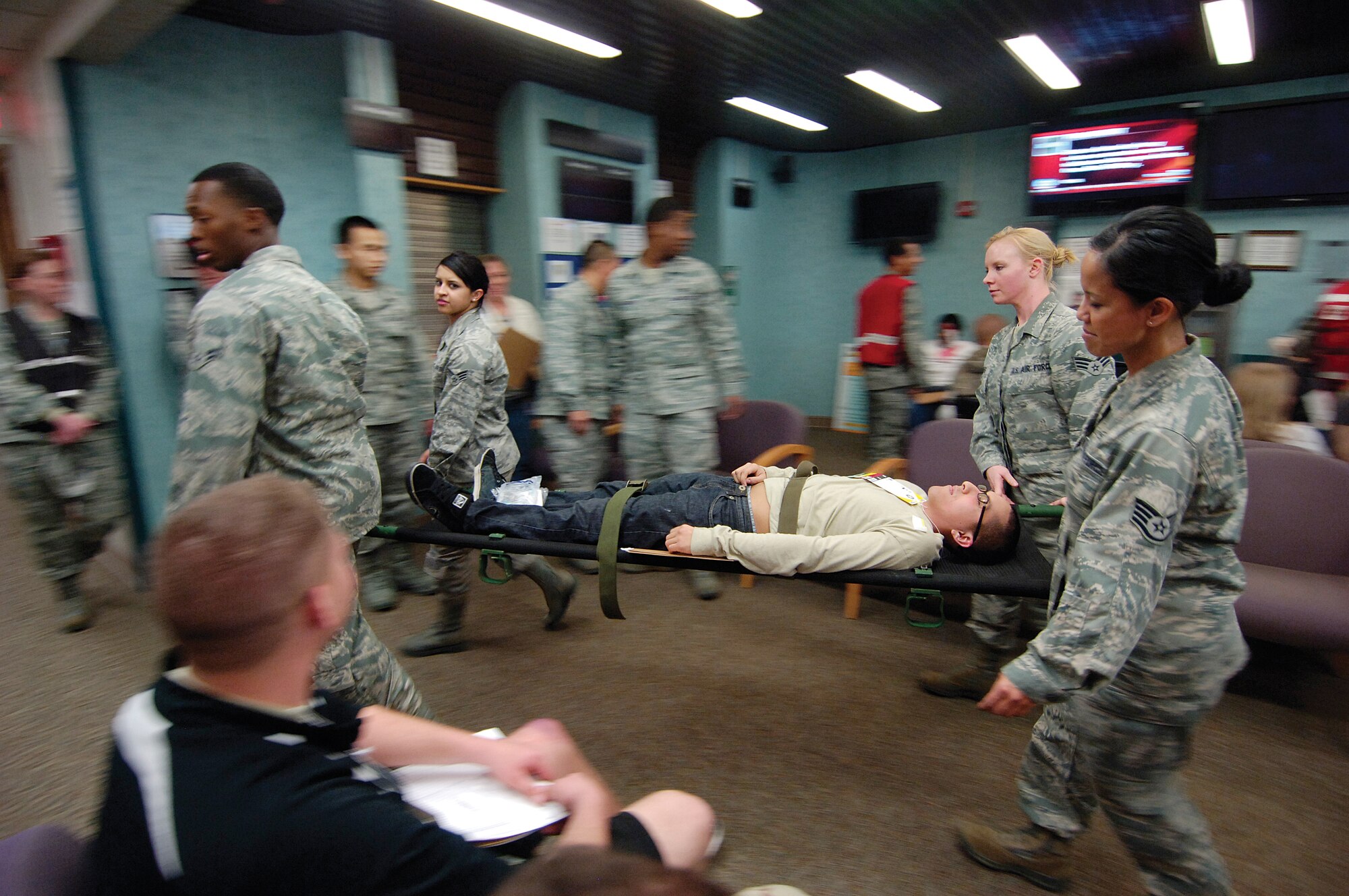 Once a calm waiting room of the 72nd Medical Group clinics, a Feb. 15 tornado disaster exercise turns the area into orderly chaos as medical personnel identify and treat dozens of moulaged victims brought to the clinics for help.  Mock victims are placed on colored tarps that signify the severity of their wounds.  Red is for victims who need immediate care. (Air Force photo by Margo Wright)