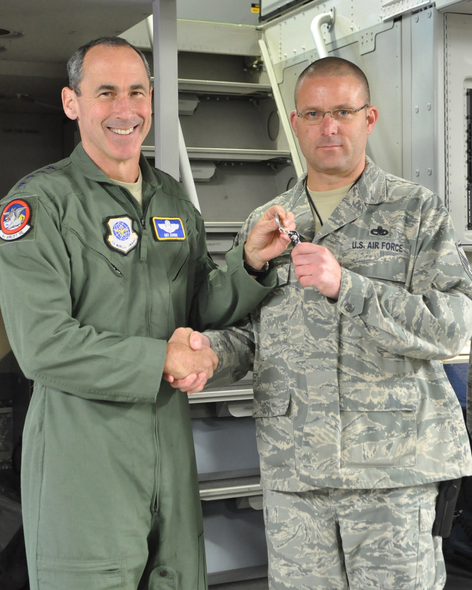 Gen. Raymond E. Johns, Jr., Air Mobility Command commander, presents a key to Master Sgt. Eric Burr, 62nd Aircraft Maintenance Squadron, after delivering McChord Field's newest C-17 Globemaster III aircraft Feb. 24, 2012, at Joint Base Lewis-McChord, Wash. (U.S. Air Force photo/Staff Sgt. Frances Kriss) 