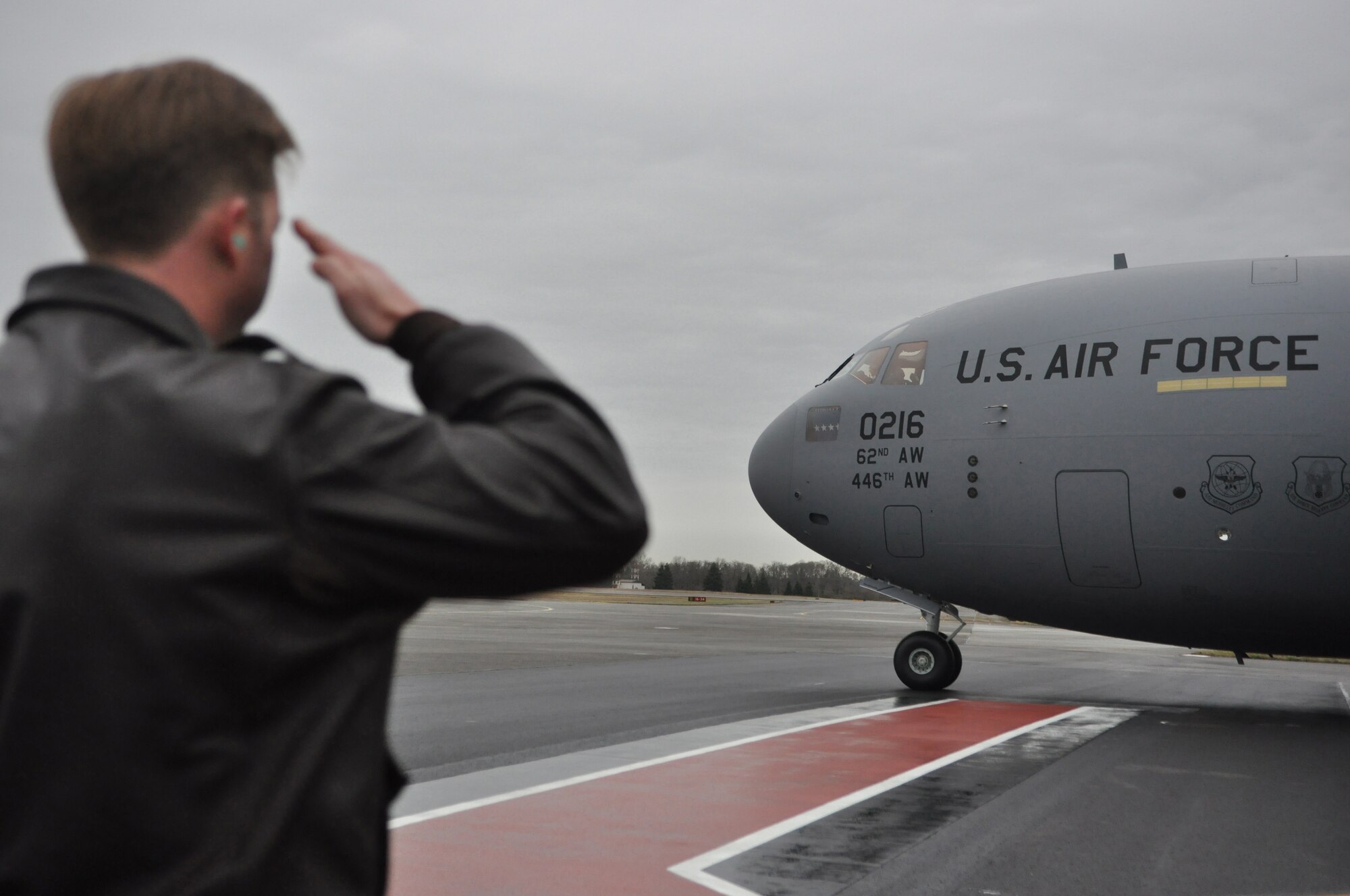 Col. Wyn Elder, 62nd Airlift Wing commander, salutes as McChord Field's newest C-17 Globemaster III aircraft is delivered by Gen. Raymond E. Johns, Jr., Air Mobility Command commander, Feb. 24, 2012, at Joint Base Lewis-McChord, Wash. In addition to delivering the C-17, Johns also addressed Airmen during a commander's call and thanked them for their hard work. (U.S. Air Force photo/Staff Sgt. Frances Kriss) 