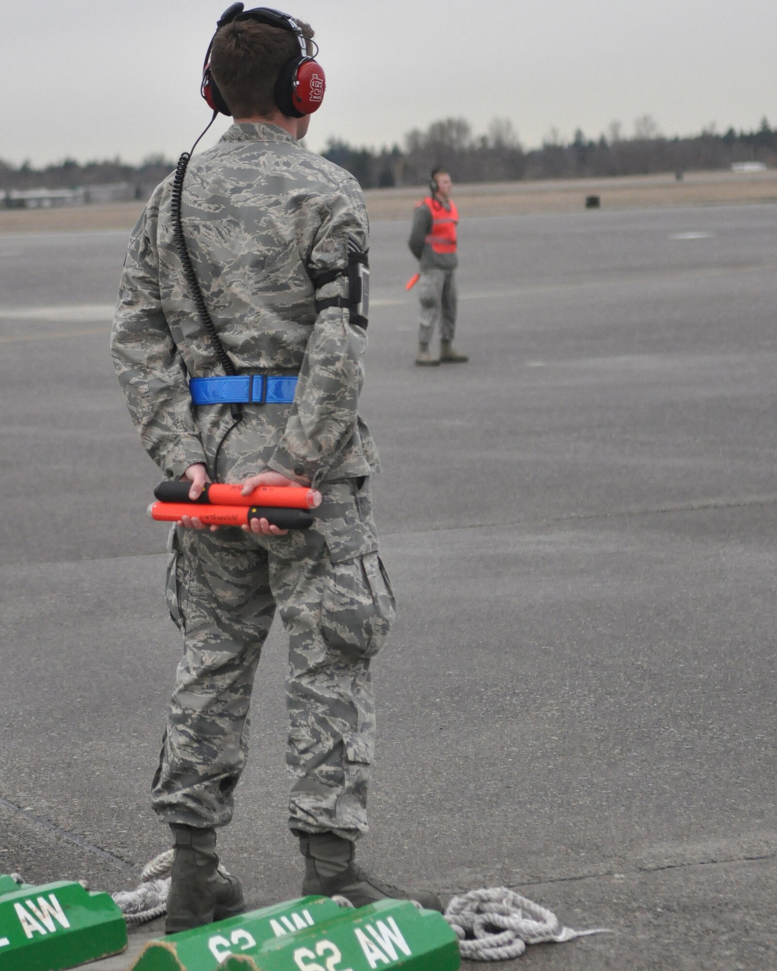 Senior Airman Devon Malarkey (right), 62nd Aircraft Maintenance Squadron, prepares to marshal in McChord Field's newest C-17 Globemaster III aircraft, while Staff Sgt. Erik Welp (left), 62nd Aircraft Maintenance Squadron, stands ready to chalk the aircraft in place Feb. 24, 2012, at Joint Base Lewis-McChord, Wash. The C-17 was delivered by Gen. Raymond E. Johns, Jr., Air Mobility Command commander. (U.S. Air Force photo/Staff Sgt. Frances Kriss) 