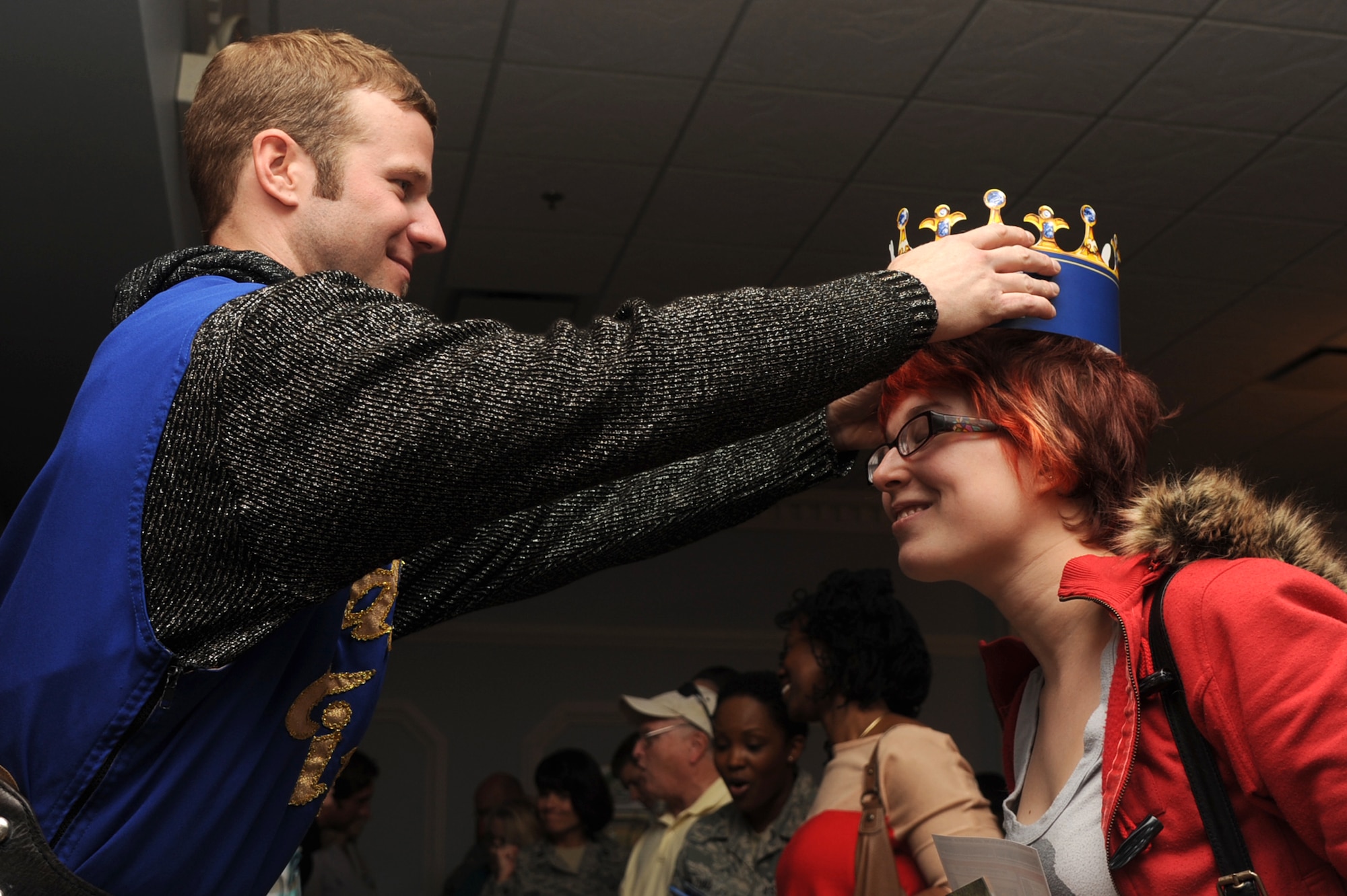 Shane Rowan crowns Lindsay Bannister during the Travel, Leisure and Entertainment Expo on Seymour Johnson Air Force Base, N.C., Feb. 22, 2012. Rowan is a sales manager for Medieval Times who offered attendees promotional souvenirs and a chance to win two free tickets. Bannister is the wife of U.S. Air Force Airman 1st Class Corey Bannister, 4th Fighter Wing honor guard member, from Orlando. (U.S. Air Force photo/Senior Airman Whitney Stanfield/Released)