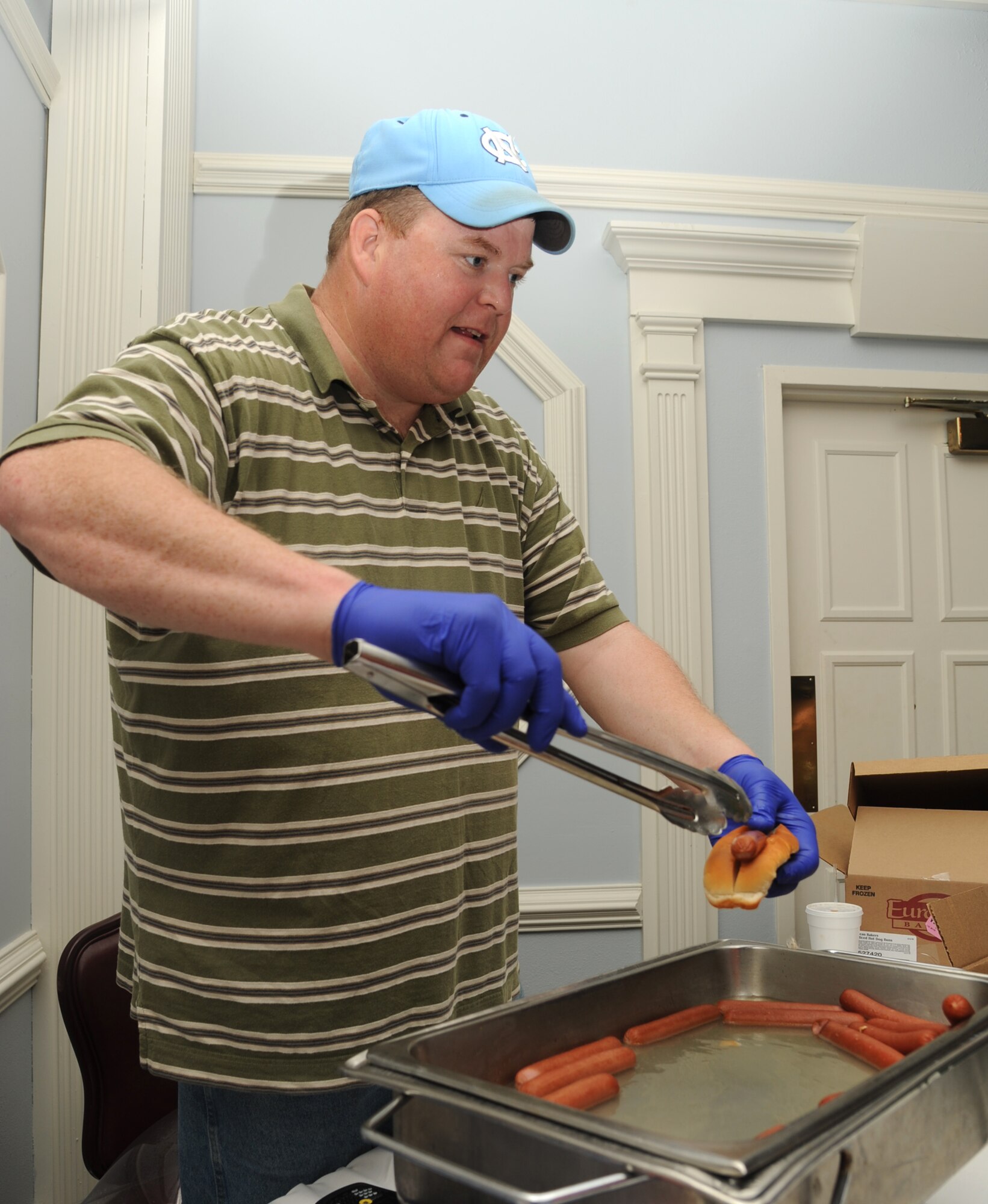 Brian Hinson prepares hot dogs at the Travel, Leisure and Entertainment Expo on Seymour Johnson Air Force Base, N.C., Feb. 22, 2012. The 4th Force Support Squadron outdoor recreation center offered Team Seymour free hot dogs and free drinks during the event. Hinson is a 4th FSS outdoor recreation assistant from Newton Grove, N.C. (U.S. Air Force photo/Senior Airman Whitney Stanfield/Released)