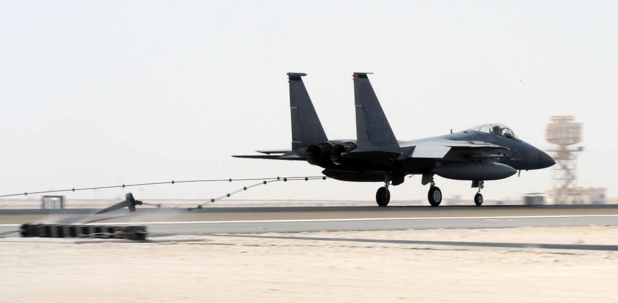 SOUTHWEST ASIA - An F-15 Eagle tests a new arresting barrier system for the 380th Air Expeditionary Wing Feb. 25, 2012. The system consists of a cable stretched across a flightline and hooked up to motorized retractors on either side. If a fighter has some type of malfunction that affects its brakes, pilots can use the arresting cable to stop safely. This was the certification test for a new system, which has to be replaced every 10 years. (U.S. Air Force photo/Staff Sgt. J.G. Buzanowski)