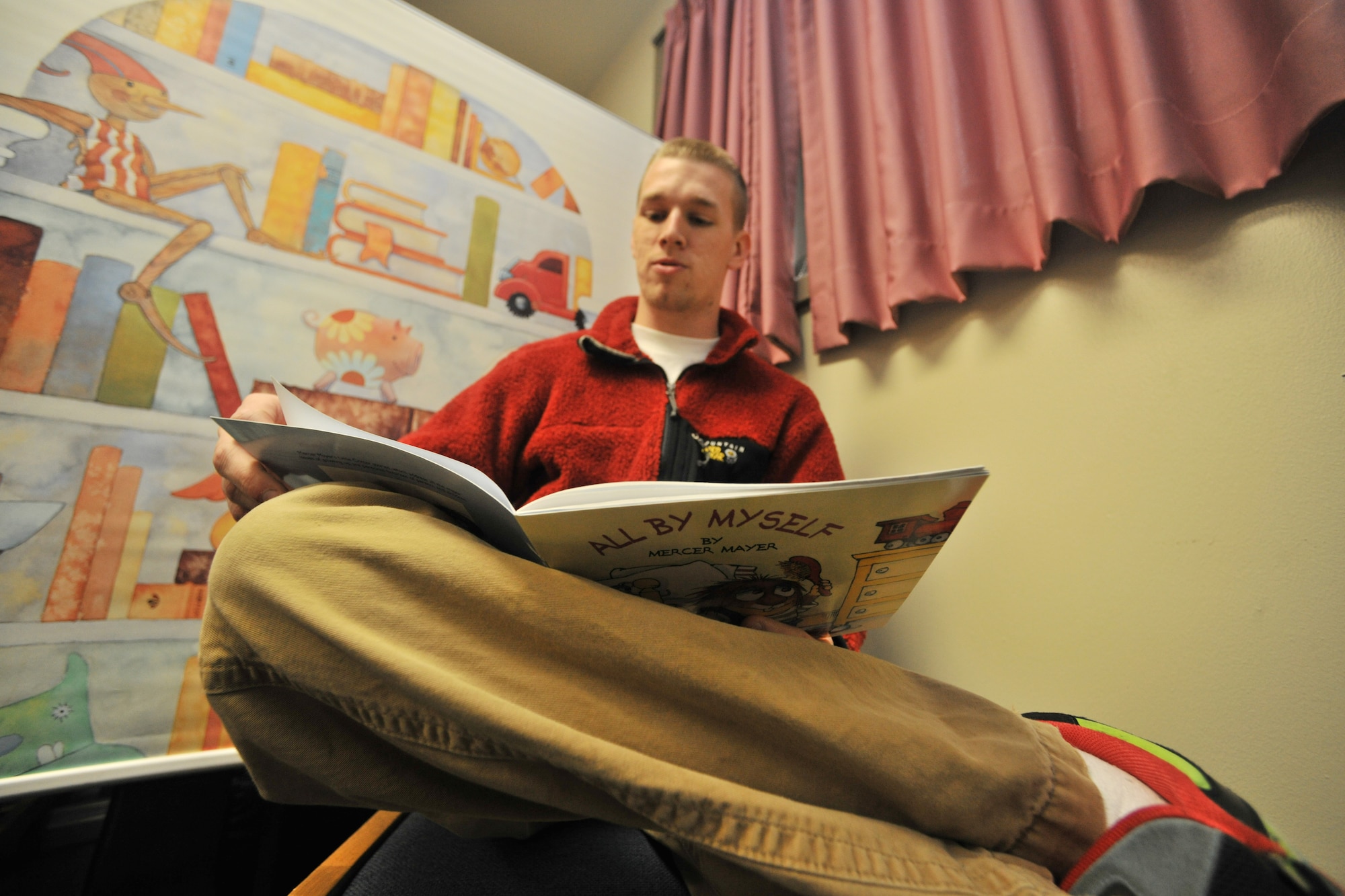 Staff Sgt. James Blaylock, 421st Expeditionary Fighter Squadron aircrew flight equipment reads a book while being recorded on DVD to send back to his family at Kunsan Air Base, Republic of Korea, Feb. 21, 2012. The United Through Reading program is offered at several locations for servicemembers to access, including airports, community locations, military medical facilities and overseas bases. To find a location nearest you contact your local USO center or go online at http://www.uso.org/united-through-reading.aspx  (U.S. Air Force photo by Senior Airman Brittany Y. Auld/Released)