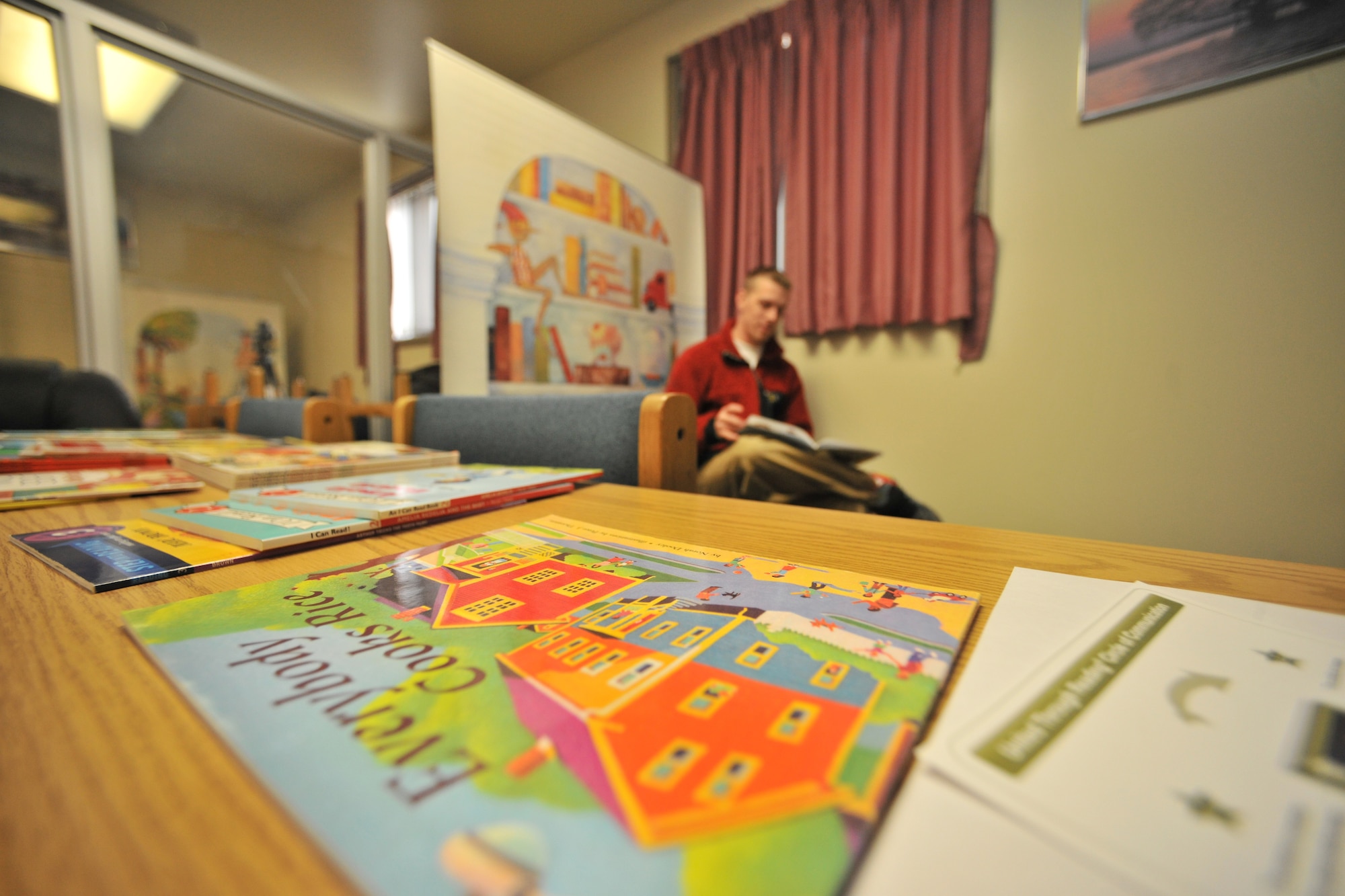 Staff Sgt. James Blaylock, 421st Expeditionary Fighter Squadron aircrew flight equipment reads a book while being recorded on DVD to send back to his family at Kunsan Air Base, Republic of Korea, Feb. 21, 2012. The United Through Reading program is offered at several locations for servicemembers to access, including airports, community locations, military medical facilities and overseas bases. To find a location nearest you contact your local USO center or go online at http://www.uso.org/united-through-reading.aspx  (U.S. Air Force photo by Senior Airman Brittany Y. Auld/Released)