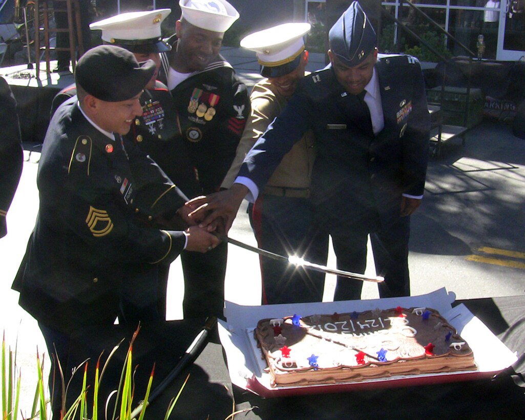 VALENCIA, Calif. — Recruiters representing the four services use a saber to cut a cake in celebration of the grand opening of a new Armed Forces Career Center at the Westfield Valencia Town Center mall here, Feb. 24, 2012. The U.S. Army Corps of Engineers Los Angeles District manages the lease of the 5,147 square foot facility.