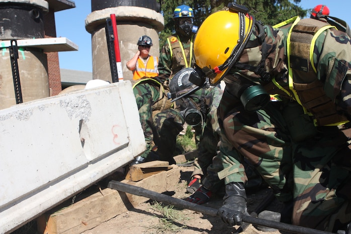 Lorton, VA - Sgt. Steven M. baduske with Victim Extracation Platoon, Initial Response Force "A," React Company, Chemical Biological Incident Response Force, assists Marines from the Tecnical Rescue Platoon, free a “victim” from under a cement block during their certification exercise 14 June.