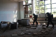 Lorton, VA - Marines with Initial Detection Platoon, Initial Response Force "A," React Company, Chemical Biological Incident Response Force, scan the area for readings of contaminates before allowing other CBIRF personnel enter the area during their certification exercise 14 June. This allows the Marines and sailors to don the propper level of personal protective equipment while still maintaing the maximum amout of mobility for life saving operations.