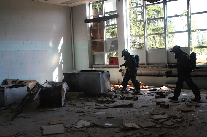 Lorton, VA - Marines with Initial Detection Platoon, Initial Response Force "A," React Company, Chemical Biological Incident Response Force, scan the area for readings of contaminates before allowing other CBIRF personnel enter the area during their certification exercise 14 June. This allows the Marines and sailors to don the propper level of personal protective equipment while still maintaing the maximum amout of mobility for life saving operations.