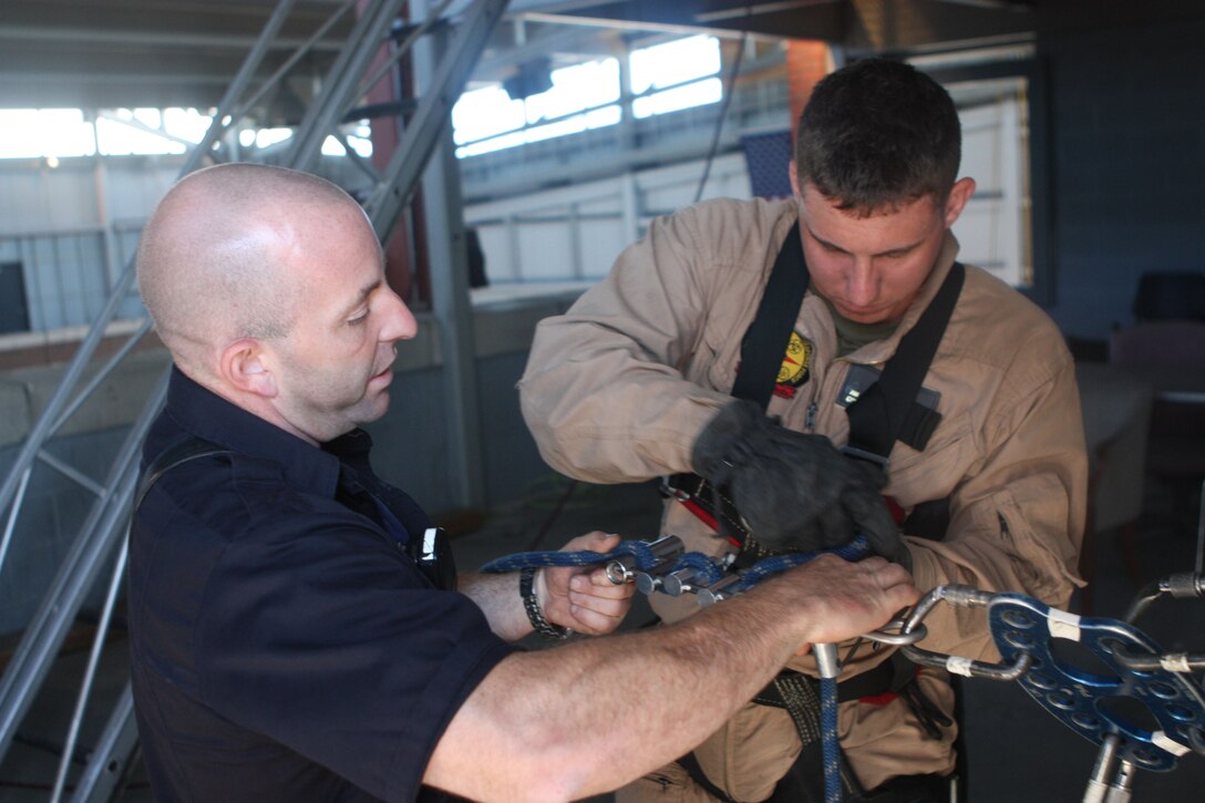 RANDALL’S ISLAND, N.Y. – A Marine with Initial Response Force B, Chemical Biological Incident Response Force gets cross training in rope rescue from a New York City Fire Department’s Special Operations Command fire fighter. Marines and sailors of CBIRF went through a week-long training evolution to involve vehicle extrication, rope rescue, and breaching and breaking through concrete. CBIRF’s Marines and sailors have trained with FDNY since July of 2000. Deputy Chief Raymond M. Downey, of FDNY’s SOC, helped CBIRF develop their technical rescue program before he later died on 9/11 in the World Trade Center towers. (released)