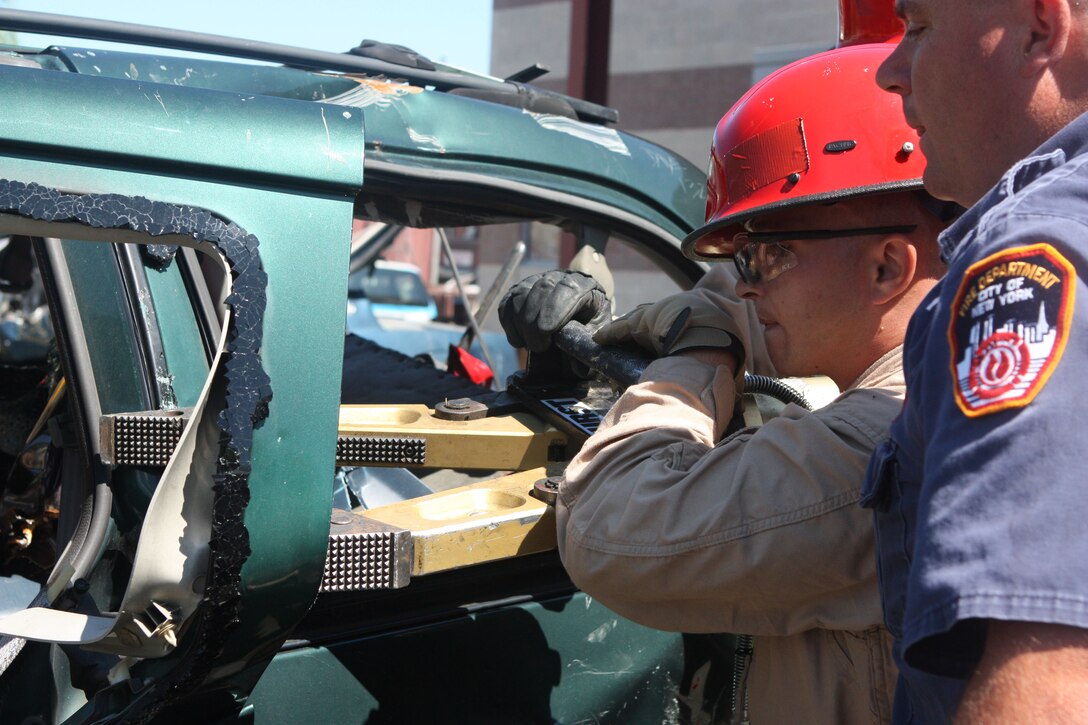 RANDALL’S ISLAND, N.Y. – A Marine with Initial Response Force B, Chemical Biological Incident Response Force gets cross training in vehicle extrication from a New York City Fire Department’s Special Operations Command fire fighter. Marines and sailors of CBIRF went through a week-long training evolution to involve vehicle extrication, rope rescue, and breaching and breaking through concrete. CBIRF’s Marines and sailors have trained with FDNY since July of 2000. Deputy Chief Raymond M. Downey, of FDNY’s SOC, helped CBIRF develop their technical rescue program before he later died on 9/11 in the World Trade Center towers. (released)