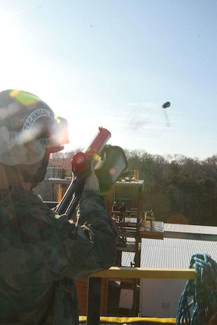 Sgt. Nick Janey, a technical rescue Marine with Chemical Biological Incident Response Force’s Technical Rescue Platoon, launches a projectile tethered to his team's tower at the opposite tower in order to allow the teams to run rescue ropes between the two repel and rescue-trainer towers for the high-angle rescue the joint 72-hour rescue training operation with the 911th U.S. Army Technical Rescue Engineer Company. This training operation allows the two units to train together building a good working relationship and familiarity of each other’s capabilities and limitations because they both cover the National Capitol Region they would have to work together if there were ever a disaster.
