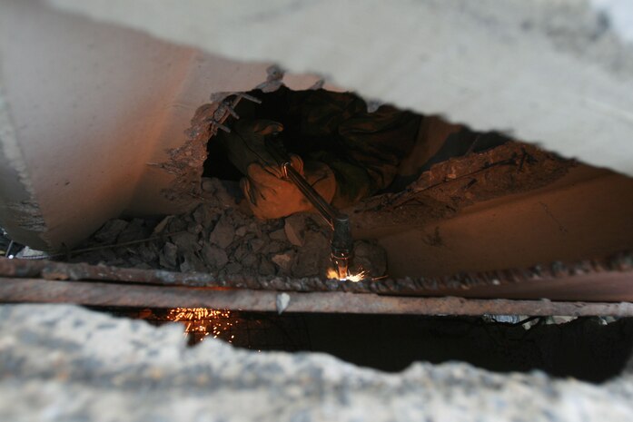 A technical rescue Marine with Chemical Biological Incident Response Force's Technical Rescue Platoon attempts to cut through a steel plate in order to gain access to a tunnel where rescuers believe victims could be trapped during a simulated collapse during the joint 72-hour technical rescue training operation with the 911th U.S. Army Technical Rescue Engineer Company at the Downey Responder Training Facility. This technical rescue training operation at DRTF allowed the two units take the opportunity to train together to build a good working relationship and familiarity of each other's capabilities and limitations, since they both cover the National Capitol Region they would work together if there were ever a disaster.
