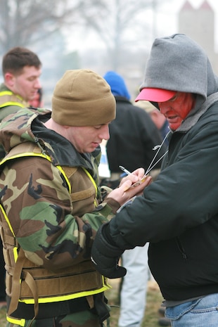 MUSCATATUCK URBAN TRAINING CENTER, Ind. - Hospital Corpsman 2nd Class Brian M. Pimpo from Initial Response Force B, Chemical Biological Incident Response Force, triages 'victims' after they have decontaminated during the second training exercise of the training operation Vibrant Response 1.1. The Marines and sailors of CBIRF drove from their base, Naval Support Facility Indian Head, in Maryland to Indiana and transitioned straight into a 24-hour training exercise.