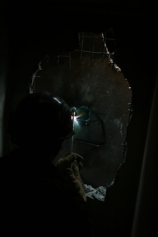 A technical rescue Marine with Chemical Biological Incident Response Force's Technical Rescue Platoon attempts to cut through a steel plate in order to gain access to a tunnel where rescuers believe victims could be trapped from a simulated collapse during the joint 72-hour technical rescue training operation with the 911th U.S. Army Technical Rescue Engineer Company at the Downey Responder Training Facility. This technical rescue training operation at DRTF allowed the two units take the opportunity to train together to build a good working relationship and familiarity of each other's capabilities and limitations, since they both cover the National Capitol Region they would work together if there were ever a disaster.