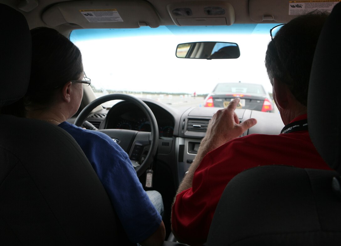 Cpl. Colleen M. Doyle, a radio operator with Combat Logistics Regiment 27, 2nd Marine Logistics Group, talks to her instructor while driving during the Richard Petty Driver Experience course at Marine Corps Auxiliary Landing Field Bogue, N.C., Sept. 21, 2011.  The course focused on braking, reaction times, tailgating and loss of control.  (Photo by Sgt. Rachael K. A. Moore)