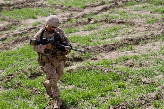 Corporal Randy Cripe, a squad leader with 2nd Platoon, Lima Company, 3rd Battalion, 7th Marine Regiment, walks through a small field, while on patrol Feb. 27, 2012. Cripe talked to local Afghan people about insurgent activity in the area. Cripe searched for a possible insurgent, questioning neighbors, friends and family.