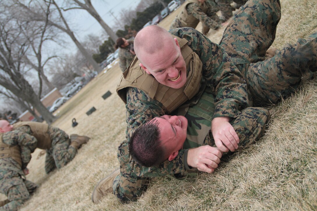 CHICAGO – Gunnery Sgt. Joshua Cunningham an assistant recruiter instructor and Sgt. Steve Regentz a NCOIC at Recruiting Station Chicago grapple during a PT session with the commanding officer here Feb. 29. The commanding officer surprised the command group and SNCOICs during an all hands with a PT session ending with a bout.