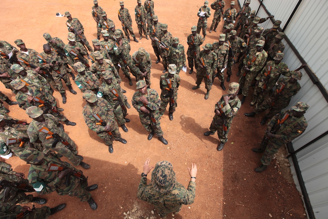 A force reconnaissance Marine goes over threat detection methods with a group of Ugandan soldiers, Feb. 28. Special Purpose Marine Air Ground Task Force 12 sent a small team of Marines into Uganda, Feb. 3, to train Ugandan forces for the fight against al-Shabaab in Somalia and the hunt for Joseph Kony and the Lord’s resistance army.::r::::n::::r::::n::::r::::n::